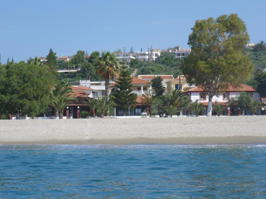 una playa con árboles y casas en el fondo en Studios Resbithas, en Gythio