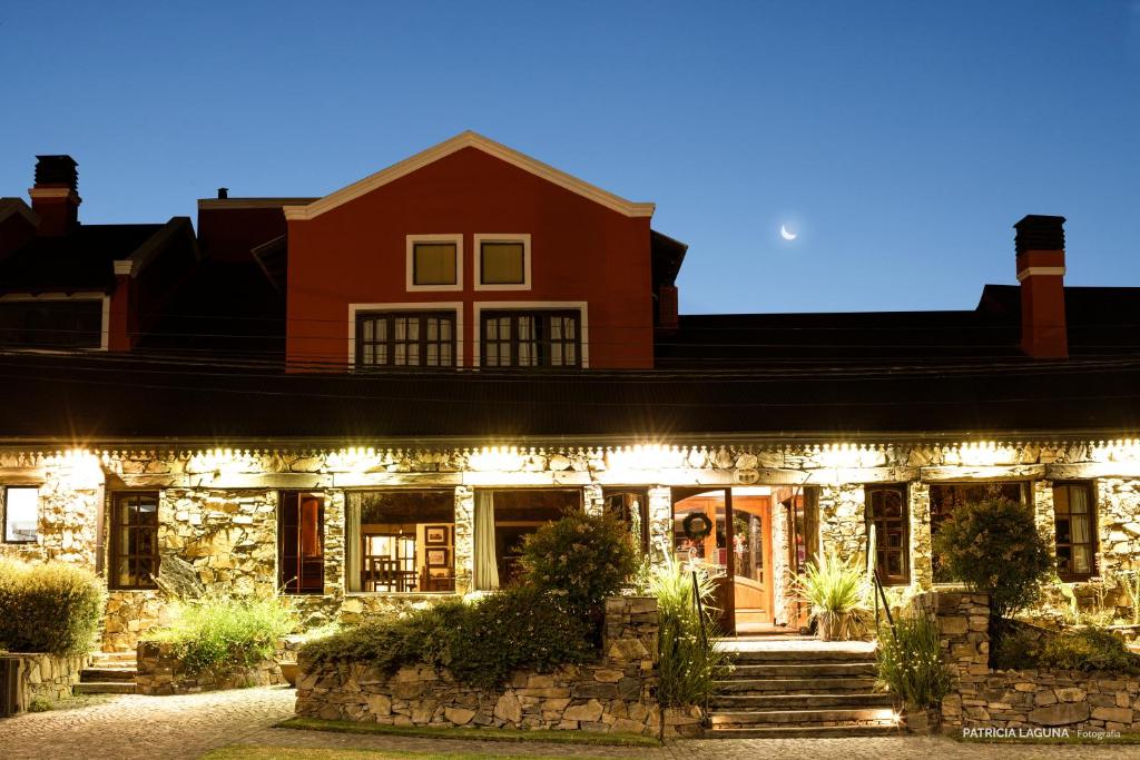 a house lit up at night with lights at Hosteria Casagrande in Tandil