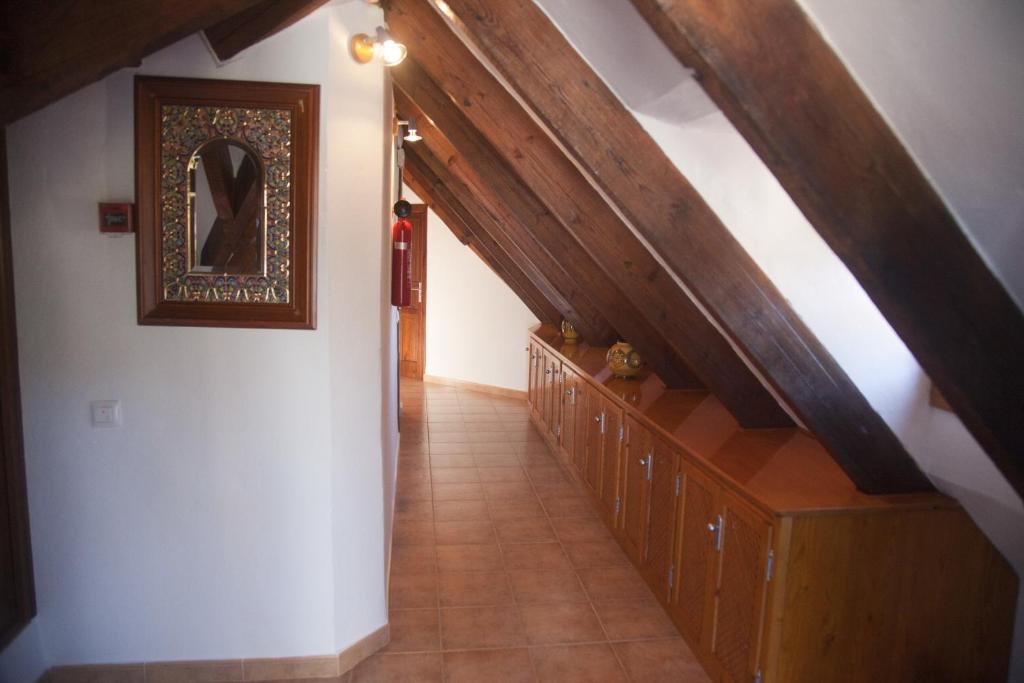 an attic hallway with a staircase and a mirror at Hostal Mar de Frente in Los Caños de Meca