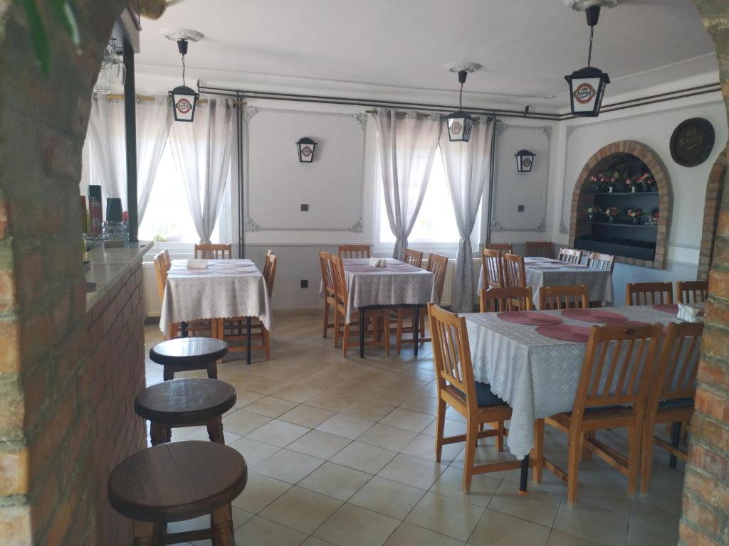 un ristorante con tavoli e sedie in una stanza di St. Kristóf Vendégház ad Abádszalók