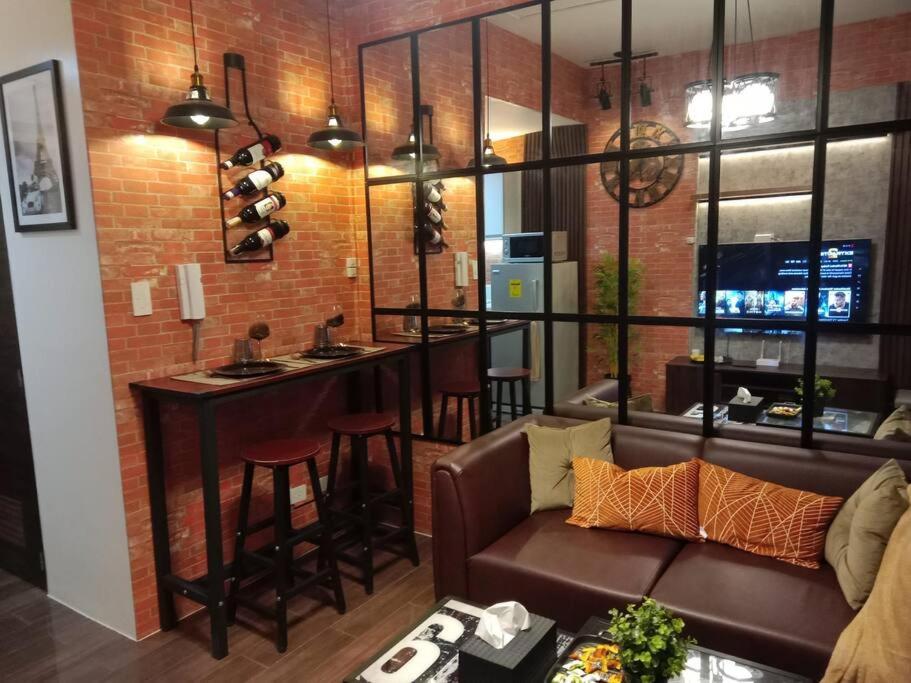 ein Wohnzimmer mit einem Sofa und einer Bar in der Unterkunft Modern Condo with Stunning Views at a Prime Location - Air Residence in Manila