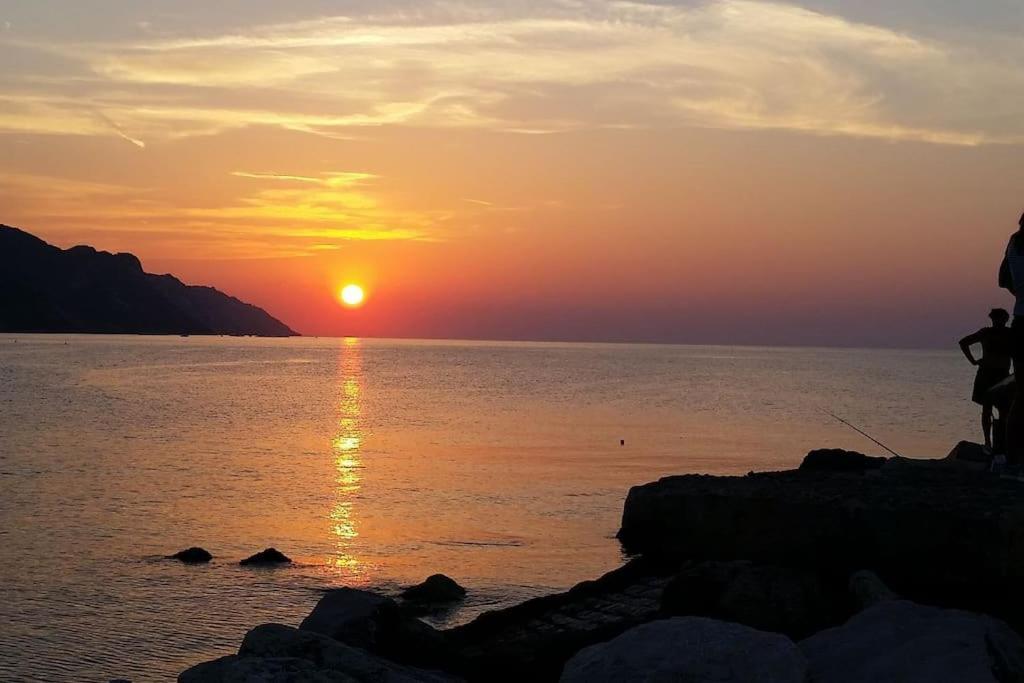 um pôr do sol sobre um corpo de água com o pôr do sol em Appartamento in villetta a 2 passi dal mare e dal centro em Pesaro