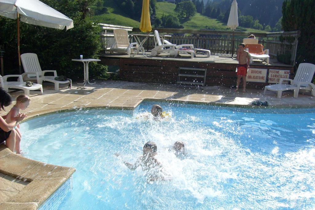 een groep mensen die in een zwembad spelen bij Chalet-Hôtel du Borderan in La Clusaz