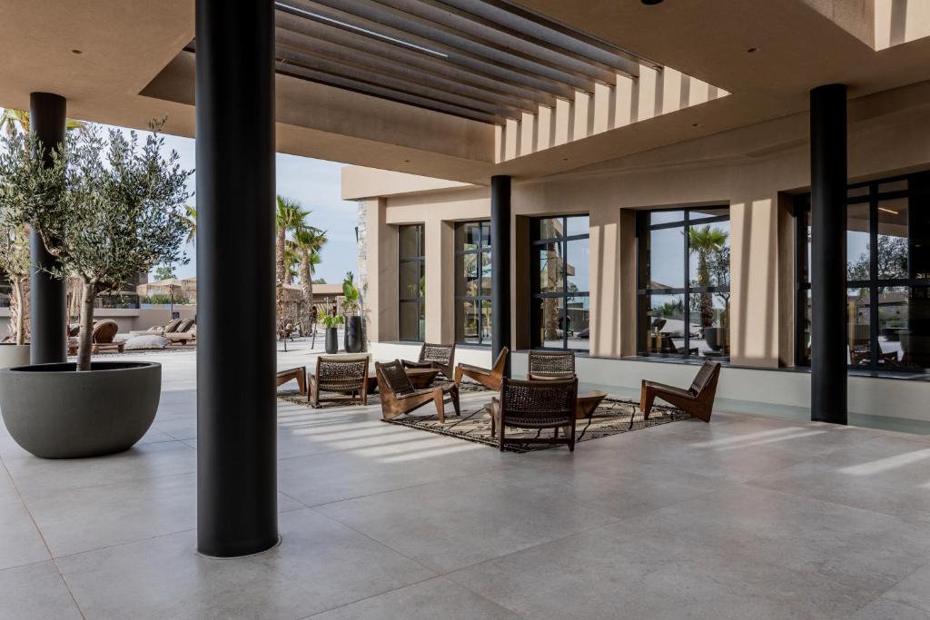 a lobby with chairs and tables and windows at Pnoe Breathing Life - Adults Only in Karteros