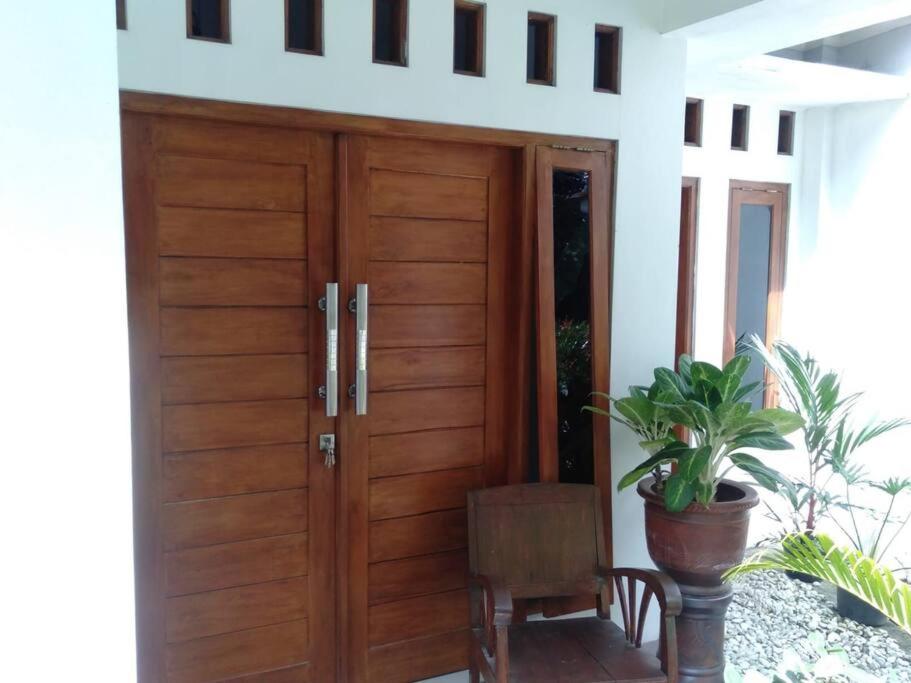 une porte en bois dans une maison avec une plante en pot dans l'établissement Narastay, à Yogyakarta
