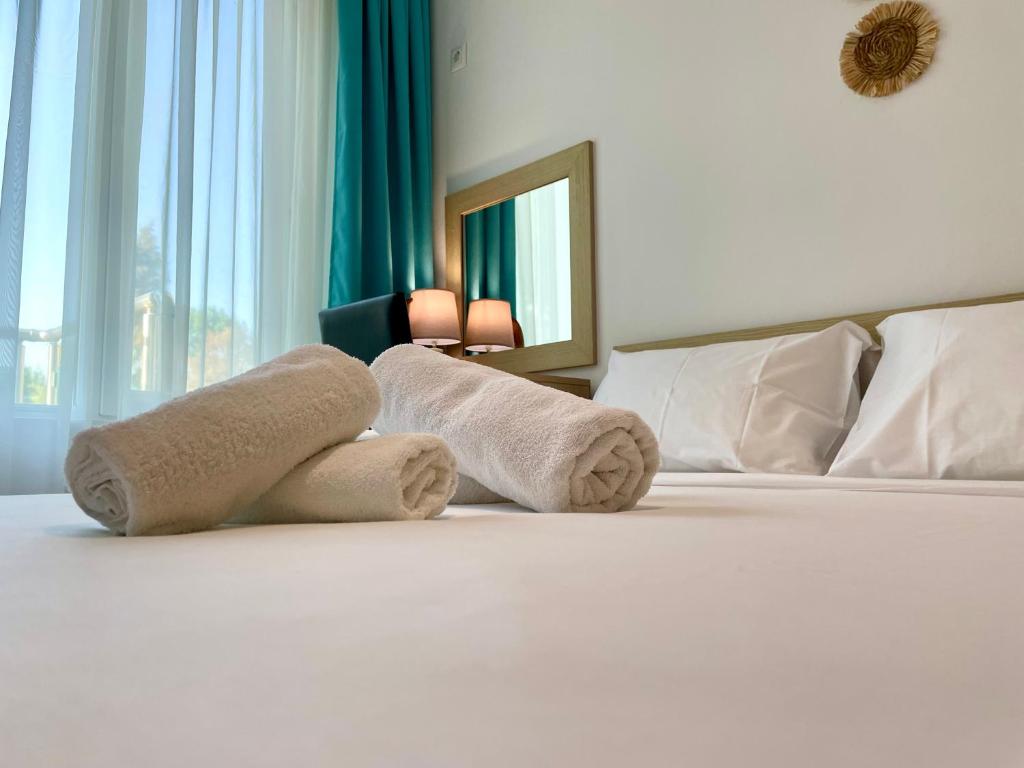 a hotel room with a bed with towels on it at First Sea Line Apartment FLORA, next to the beach in Pomorie