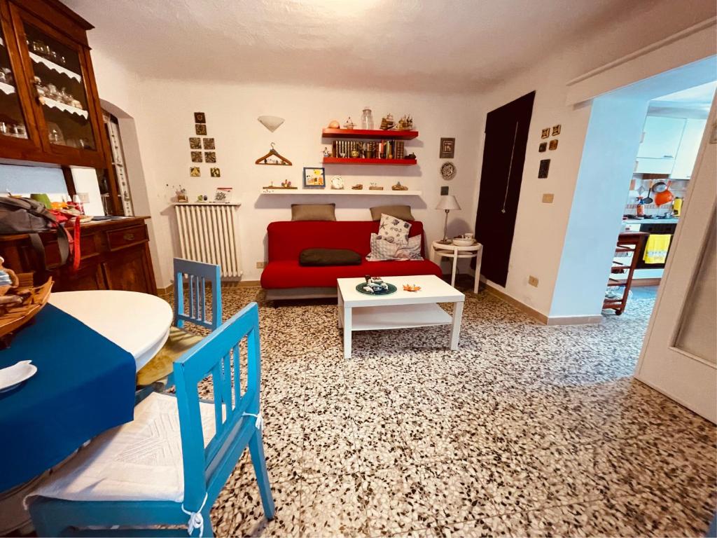 un soggiorno con divano rosso e tavolo di Casa Blu a Pisa