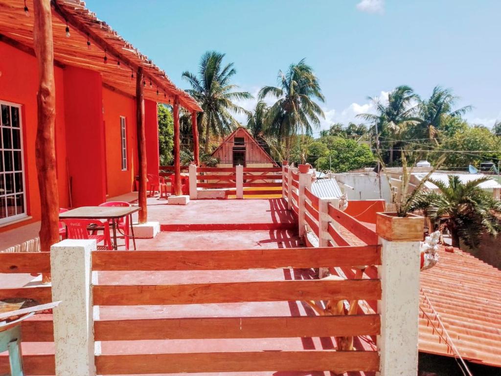 a wooden walkway leading to a red building at Tribe Beachville in El Cuyo