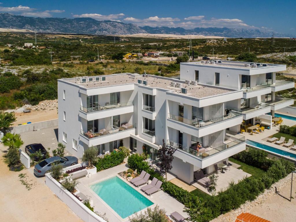 uma vista aérea de uma casa branca com uma piscina em VILLA CALA, Hotel Rooms&Apartments em Novalja