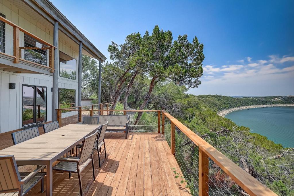 a deck with a table and chairs and a view of the ocean at Perched Above the River in Lago Vista
