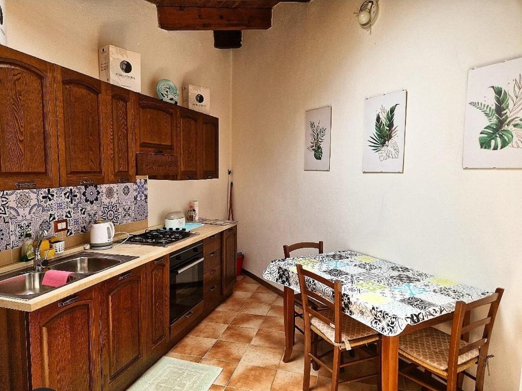 BaradiliDomus de Jara - Casa Usai的厨房配有桌子、水槽和桌椅