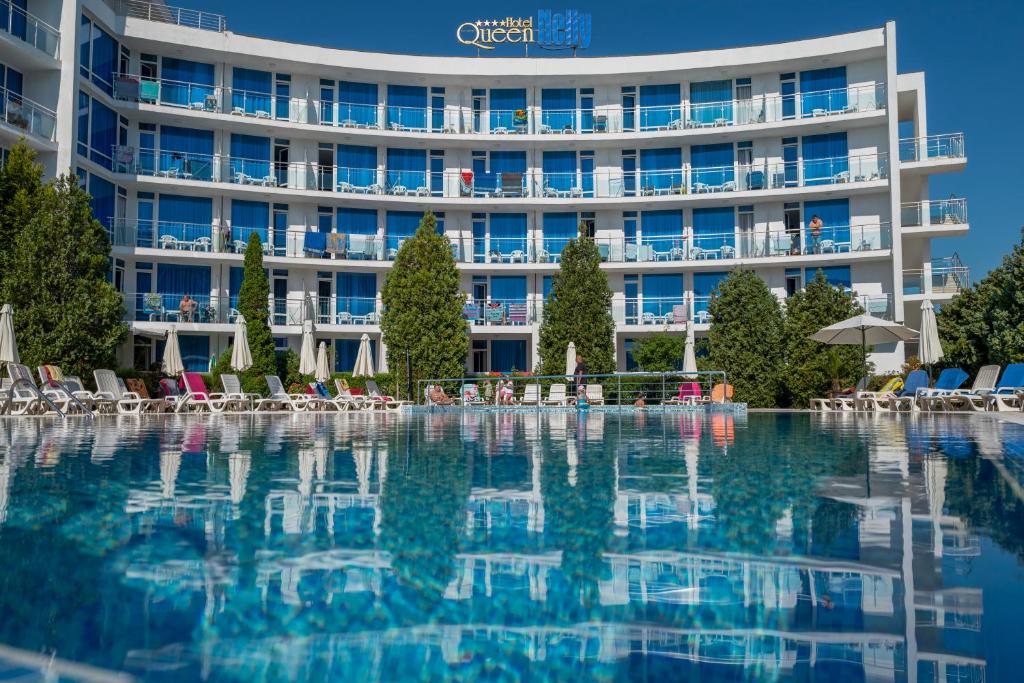 a hotel with a swimming pool in front of a building at Queen Nelly in Primorsko