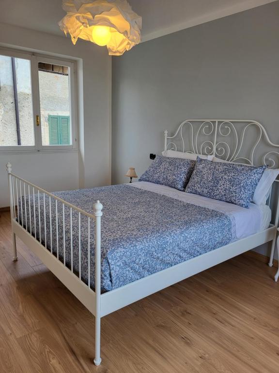 um quarto com uma cama branca e almofadas azuis em Casa Onorina, lago d’Orta em Bolzano Novarese