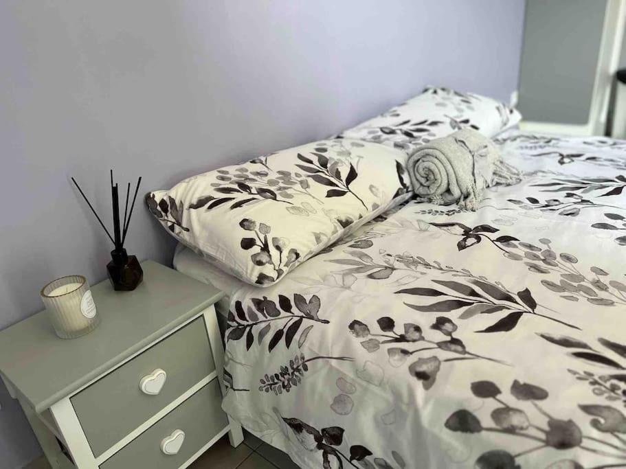 a bed with a black and white comforter and a night stand at Beautiful flat with sunny balcony in heart of Nice Le Port in Nice