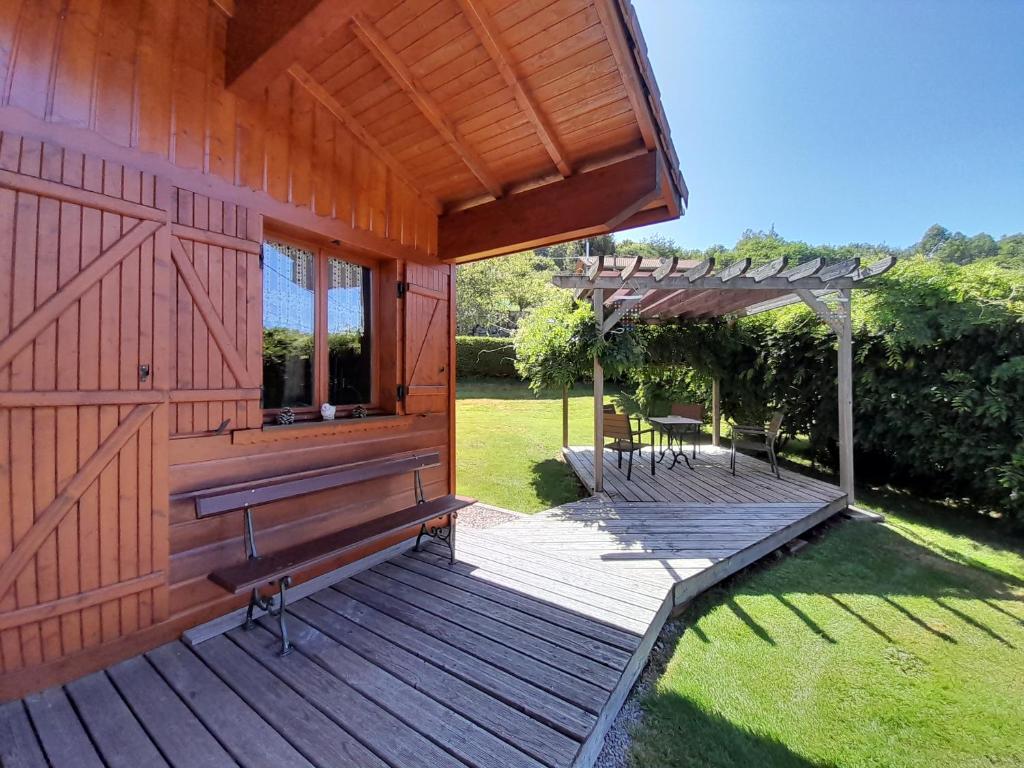 a wooden house with a deck and a pergola at Chalet de Grettery in Saulxures-sur-Moselotte