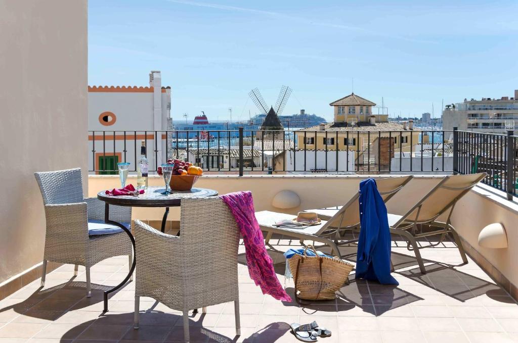 a patio with a table and chairs on a balcony at StayCatalina Boutique Hotel-Apartments in Palma de Mallorca