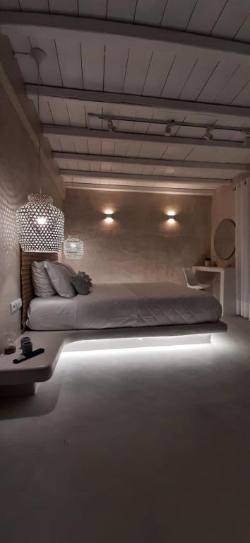 a bedroom with a large bed with lights on it at Moustakas Beach Apartments in Adamas