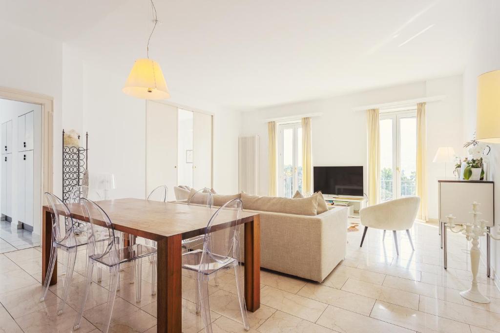 ein Wohnzimmer mit einem Tisch und einem Sofa in der Unterkunft Villa Magnolia - High standing floor in Locarno