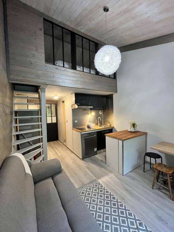 uma sala de estar com um sofá e uma cozinha em Le Petit Chalet Addicted to Paradise em Tignes