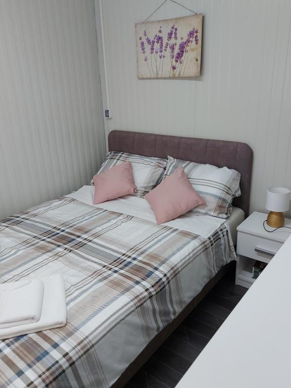a bedroom with a bed with pink pillows at Mobile Home Marta in Senj