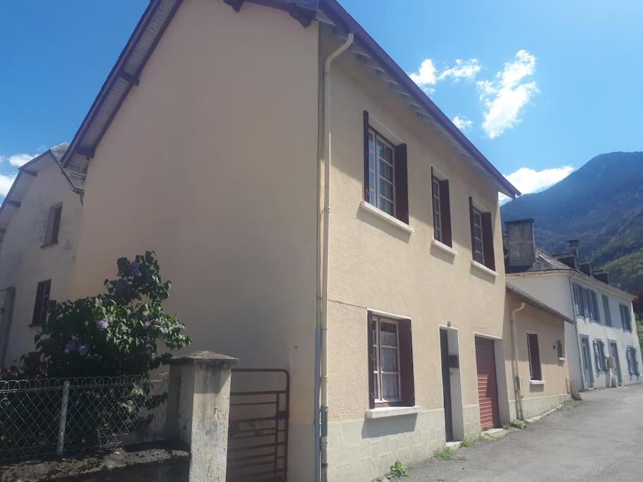 un bâtiment blanc avec une porte à côté d'une rue dans l'établissement La maison de Nestalas, à Pierrefitte-Nestalas