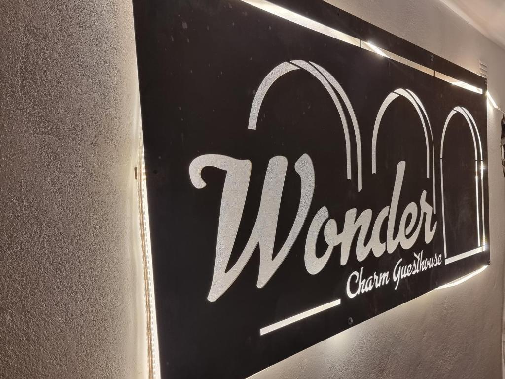 un cartello per un ristorante su un muro di Wonder Charm Guesthouse ad Albufeira