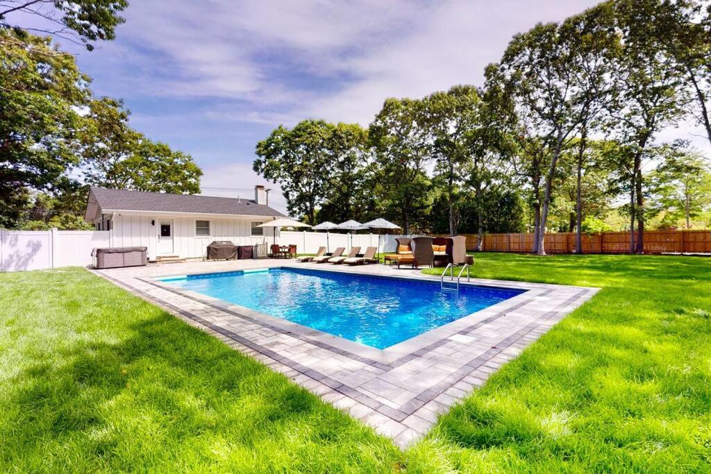 a swimming pool in the middle of a yard at Brand new house with an all year round hot tub. in Westhampton Beach