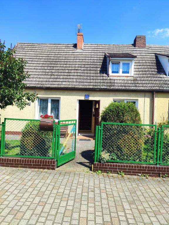 uma cerca verde em frente a uma casa em Pokoje u Natalii em Dziwnów