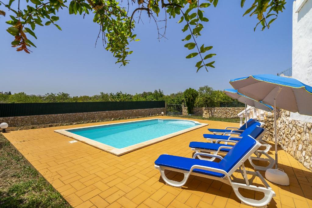 een zwembad met ligstoelen, een parasol en een zwembad bij Casa Solar in Guia