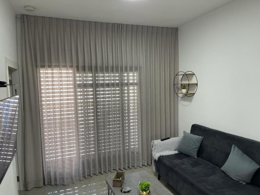 a living room with a couch and a large window at פסגת יובלים in Qiryat Shemona