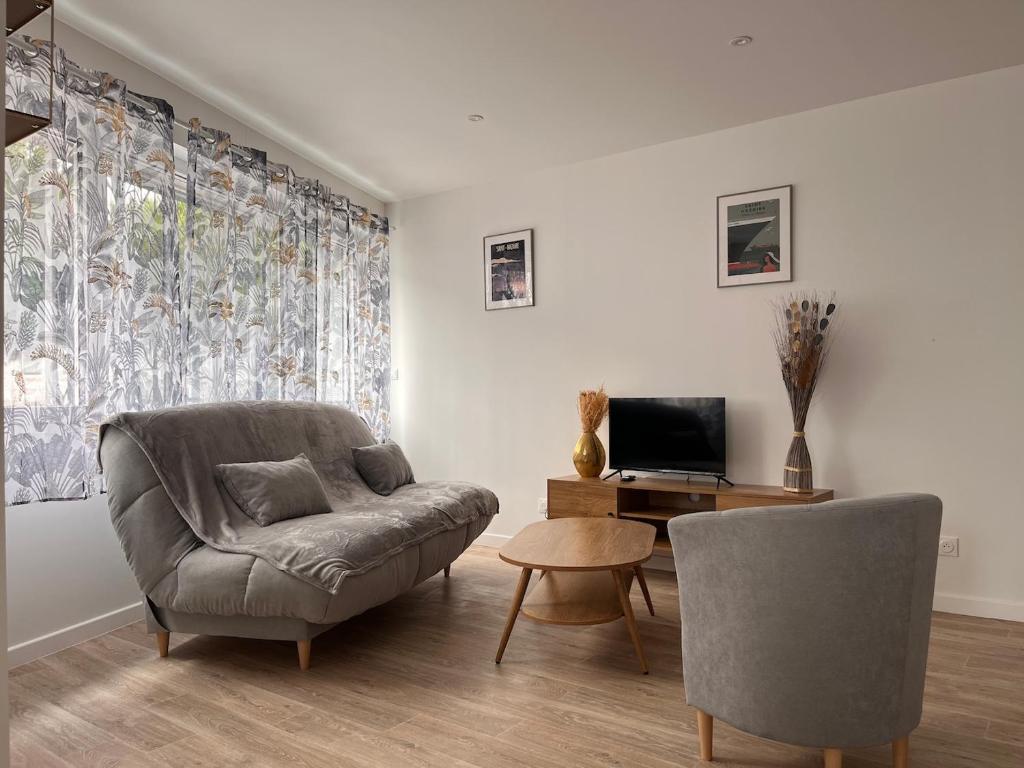 Una sala de estar con un sofá y un televisor. en Studio récent, entièrement équipé, proche Chantiers et Airbus, en Saint-Nazaire