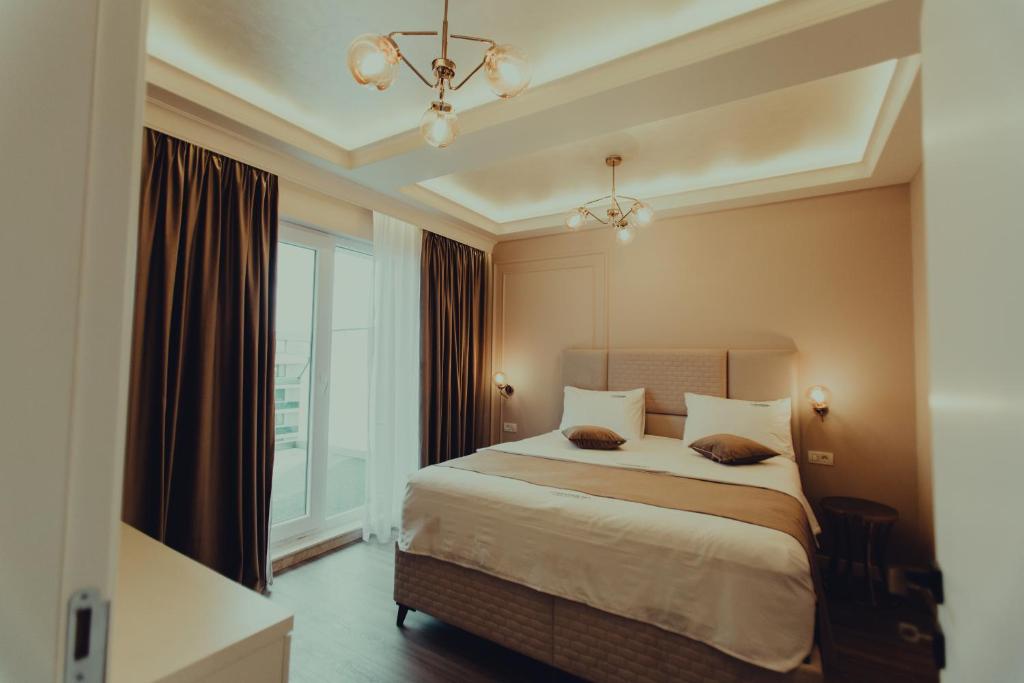 a bedroom with a large bed and a window at AVANGARDE SEA Luxury Apartments in Mamaia Nord