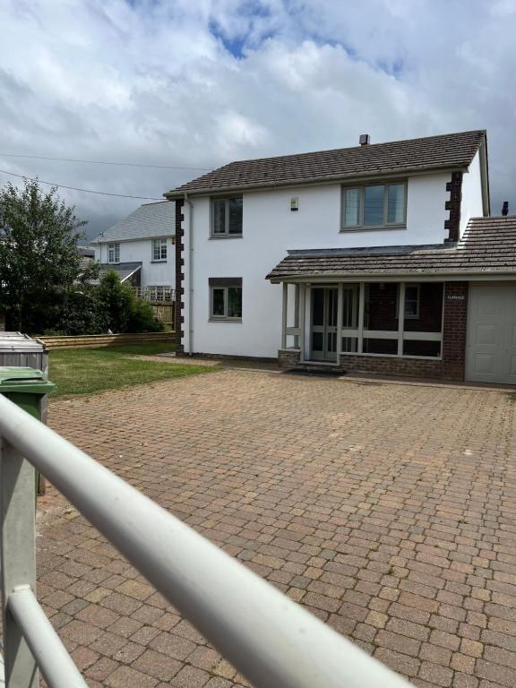 a white house with a brick driveway at Home in Buckland Brewer near Bideford in Bideford