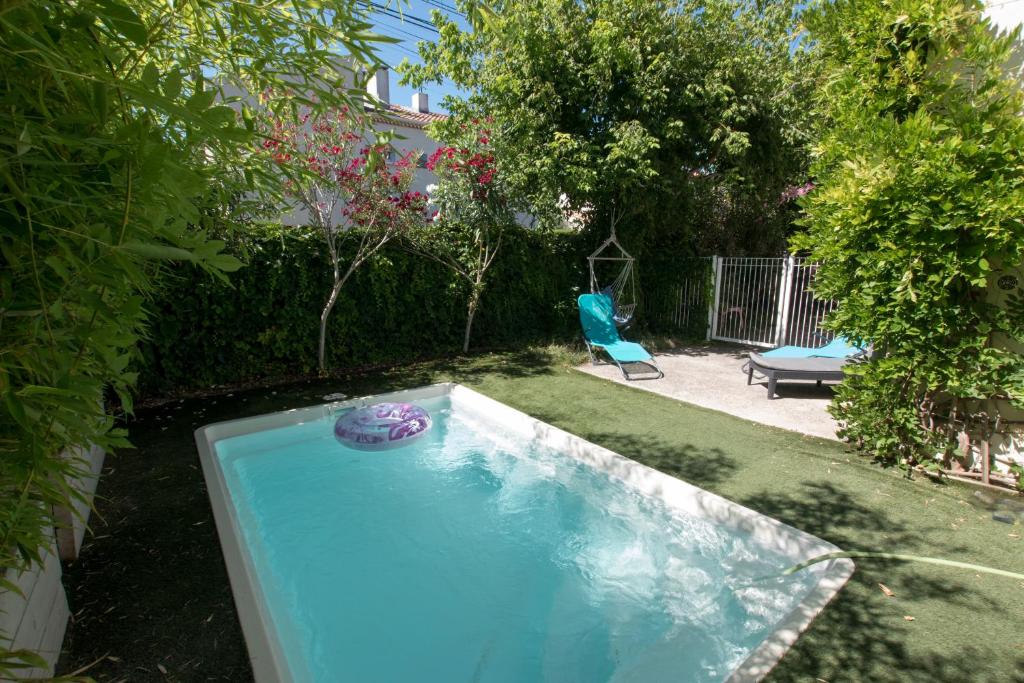 una piscina con un frisbee en un patio en Maison Manon, Piscine - Clim - Jardin, en Arles