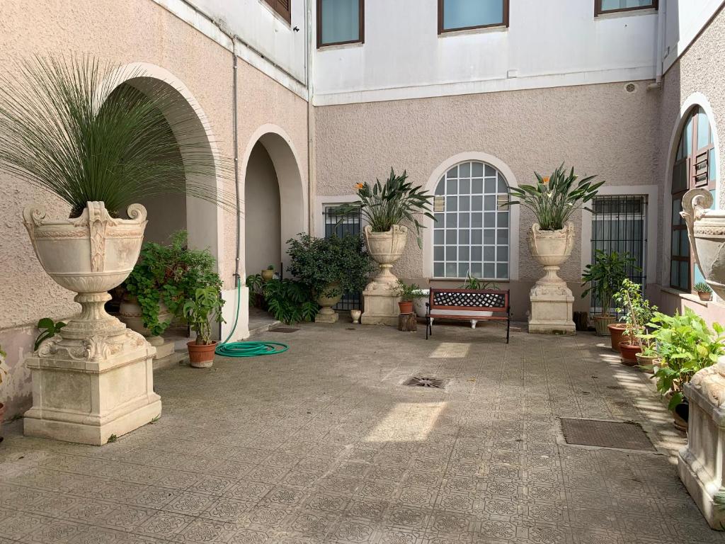 einen Innenhof mit Töpfen aus Pflanzen und einem Gebäude in der Unterkunft B&B Lecce26 in San Pietro Vernotico