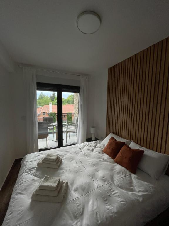 a bedroom with a large white bed with towels on it at New Aesthetic Haven Hedonica 6 Apartment in Vrdnik in Vrdnik