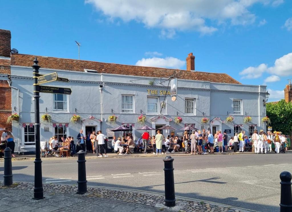 a crowd of people standing outside of a building at Swan Hotel by Greene King Inns in Thaxted