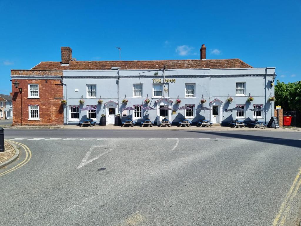 a white building on the side of a street at Swan Hotel by Greene King Inns in Thaxted