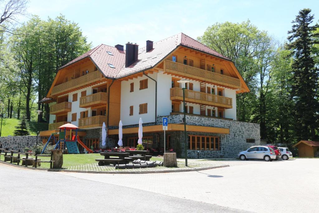 ザグレブにあるAparthotel Snjezna Kraljicaの大きな木造の建物(テーブル付)