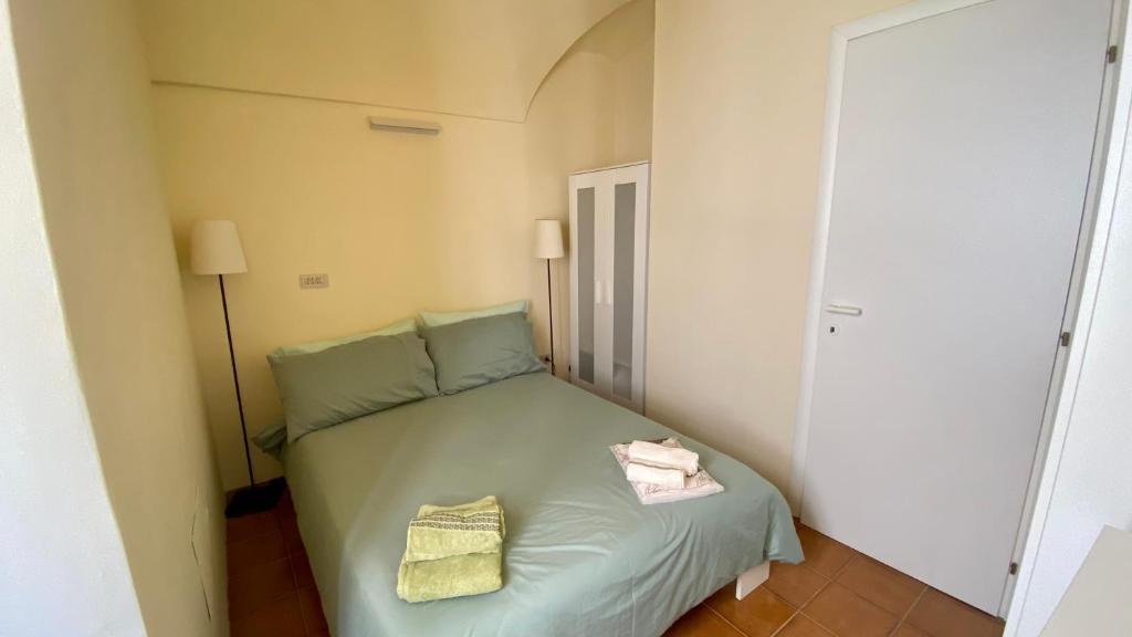 - une petite chambre avec un lit vert et 2 serviettes dans l'établissement I Tetti di Via Corradi, à Sanremo