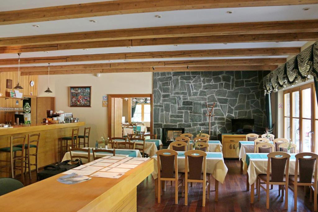 restauracja ze stołami i krzesłami oraz kamienną ścianą w obiekcie Aparthotel Snjezna Kraljica w Zagrzebiu