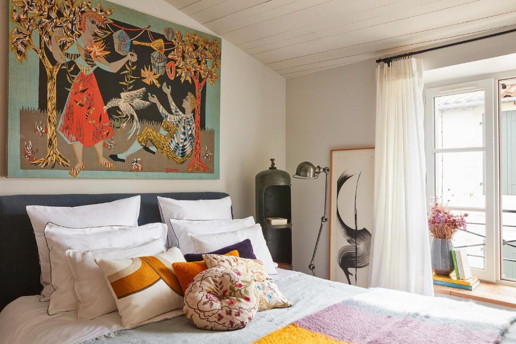 1 dormitorio con 1 cama con una pintura en la pared en Maisons 322 - La Flamboyante en Le Bois-Plage-en-Ré