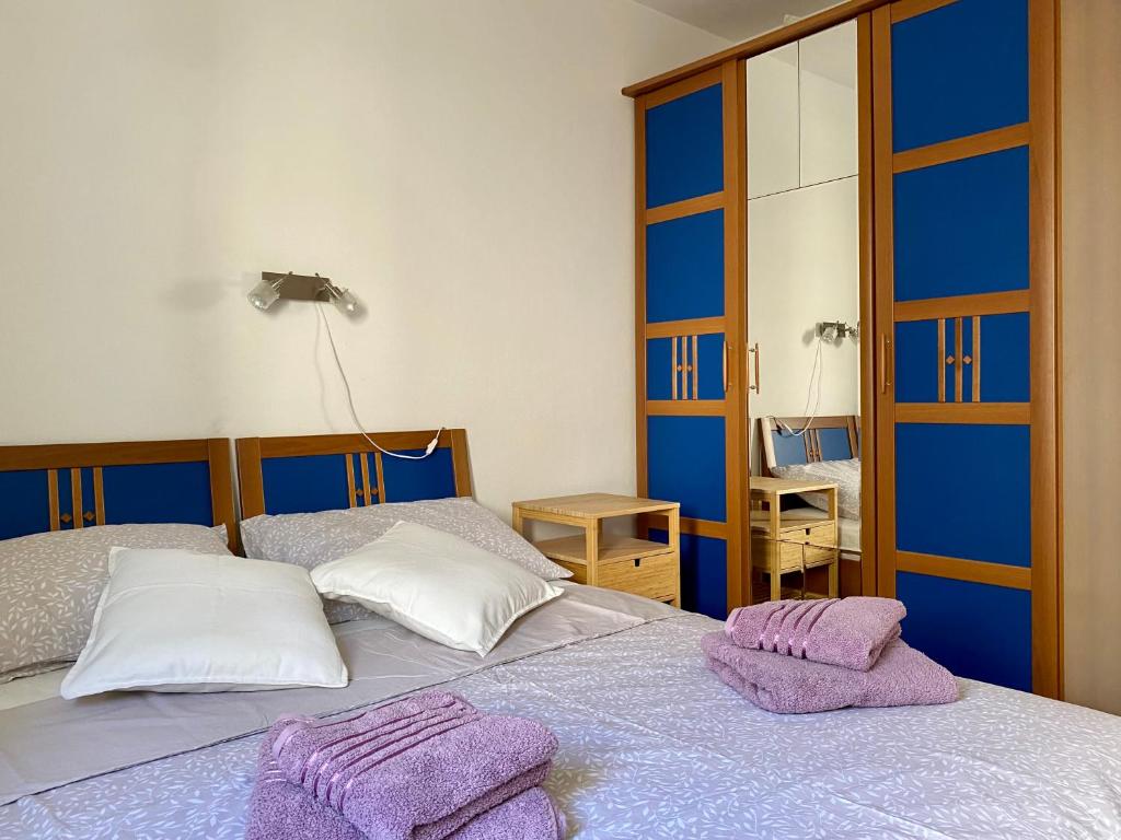 two beds in a room with purple towels on them at 2 bedrooms apartment with sea view in Baška Voda