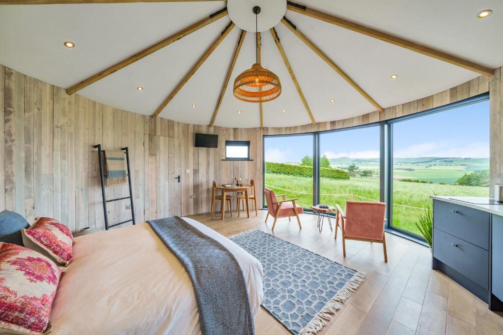 um quarto com uma cama grande e uma mesa com cadeiras em The Roundhouses em Alnwick