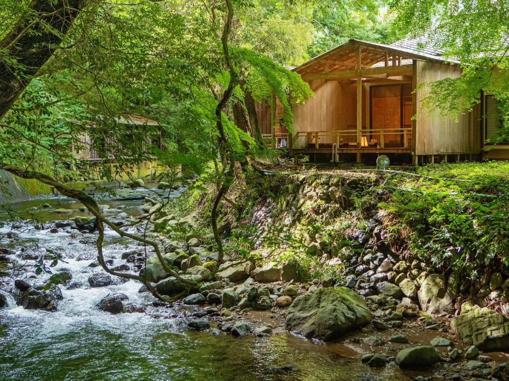 eine Hütte im Wald neben einem Fluss in der Unterkunft Mizumari in Kawazu
