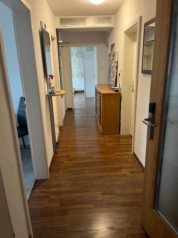 pasillo de un apartamento con suelo de madera y puerta en Schönes 3 Zimmer Apartment "Cocco", en Ludwigsburg