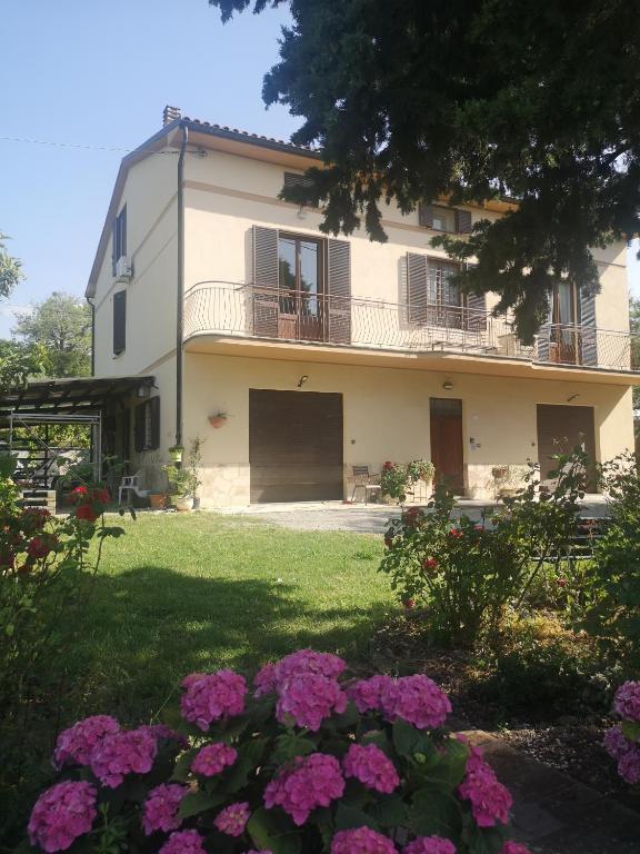 una casa grande con flores en el patio en Casa Raffaello, en Castiglione dʼOrcia