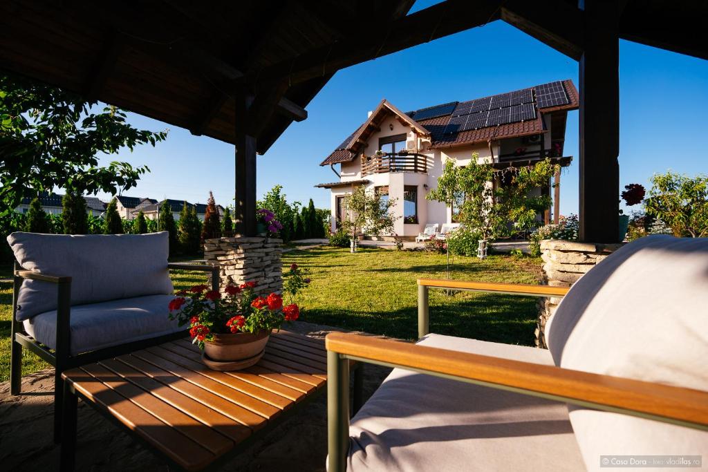 a patio with a chair and a house in the background at Casa Dora in Suceava