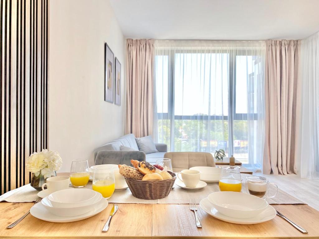 - une table à manger avec des assiettes et des verres de jus d'orange dans l'établissement Comfort & Classy 1Bed Аpartment for 4 Guests, à Plovdiv