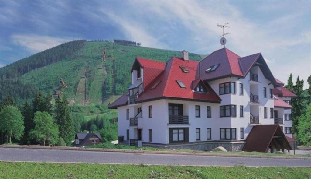 una gran casa blanca con techo rojo en M+M Apartmán en Harrachov